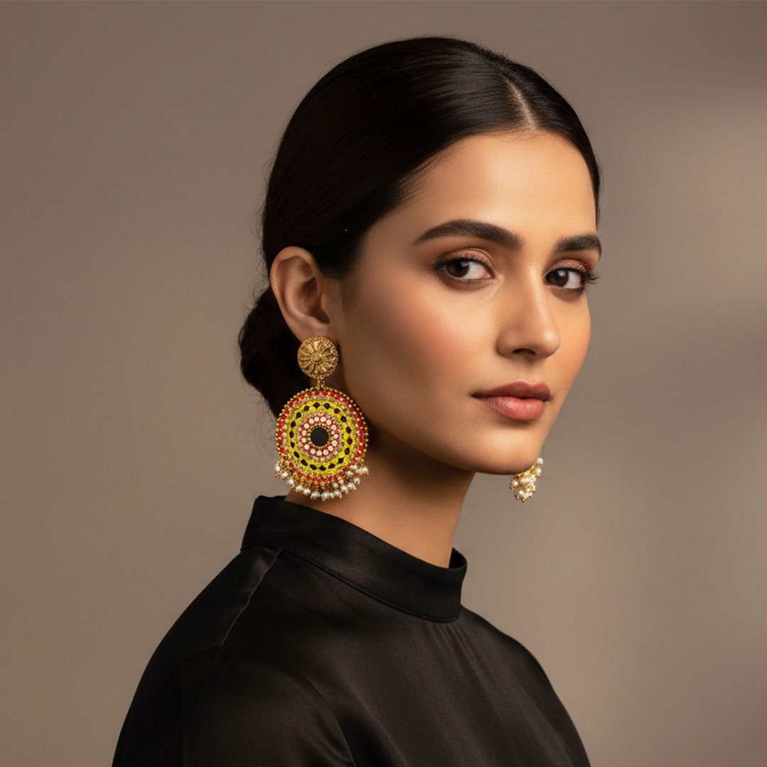 Pair of ornate silver jhumka earrings with circular blue and maroon floral design and intricate hanging beads