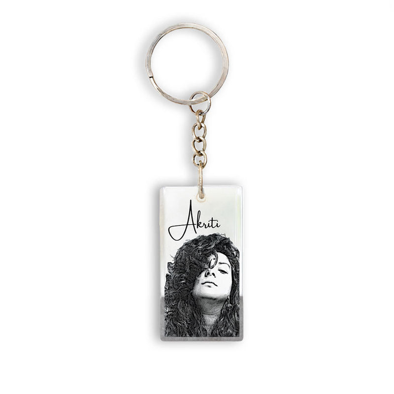 Silver keychain with rectangular photo pendant featuring black and white portrait of woman with curly hair and the name Akriti