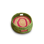 Woven basket with green and pink pattern on a white background