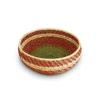 Woven basket with red and green pattern on a white background