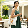 Woman holding a cup and a tote bag with a design outdoors