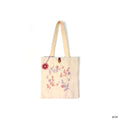 Cream canvas tote bag with pink and purple floral embroidery and a button closure