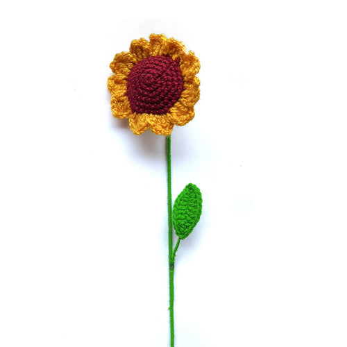 Crocheted sunflower with a green stem on a white background