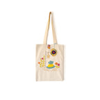 Beige tote bag with embroidered blue and yellow dress, flowers, and hanging ornament on white background