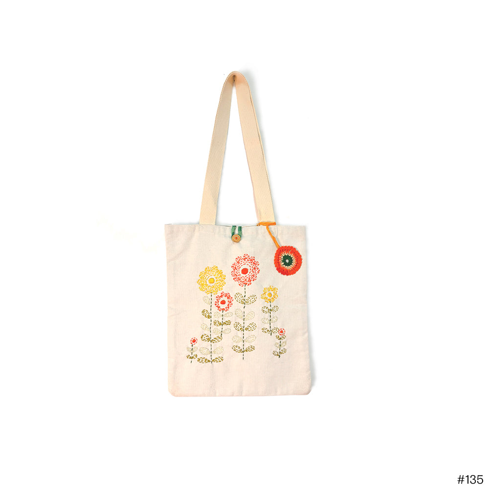 Cream canvas tote bag with embroidered colorful floral design and long beige straps