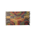 Multicolored geometric patterned rug with fringes on a white background