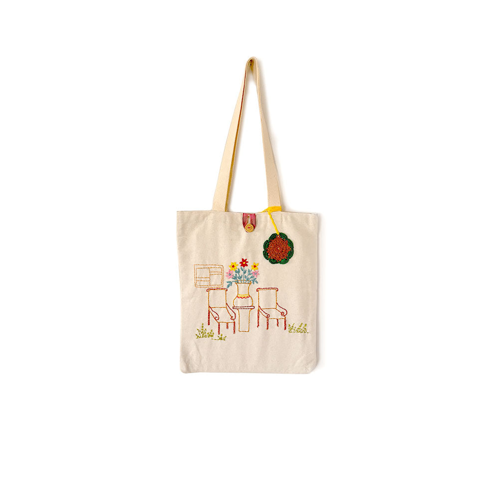 Beige tote bag with a colorful design on a white background