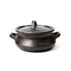 Black ceramic pot with lid on a white background