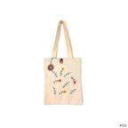 Beige canvas tote bag with embroidered colorful floral design and button closure