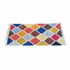 Colorful geometric patterned rug with tassels on a white background