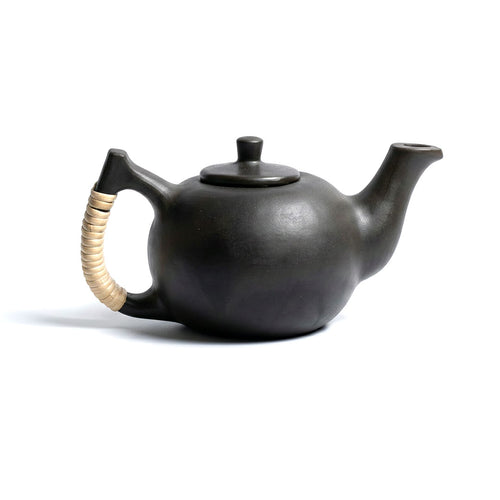 Black ceramic teapot with a gold handle on a white background