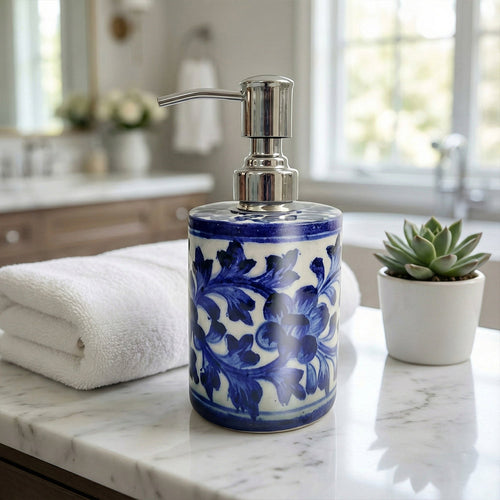 Decorative soap dispenser with blue floral pattern on a marble countertop.