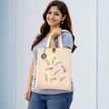 Woman holding a tote bag with floral designs against a light blue background