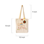 Beige canvas tote bag with floral and chair embroidery, measuring 13x11.5 inches with 11-inch straps