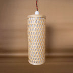 Cylindrical rattan pendant light on a brown background