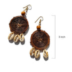 Pair of earrings with wooden beads and shell-like elements on a white background