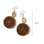 Pair of brown circular earrings with shell accents on a white background