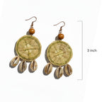 Pair of earrings with circular designs and shell-like elements on a white background