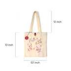 Beige tote bag with embroidered pink and purple floral design and measuring dimensions
