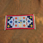 Decorative rug with geometric pattern on a textured brown wall