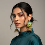 Woman wearing large, ornate earrings against a neutral background