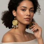 Woman wearing large, decorative earrings against a neutral background