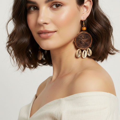 Woman wearing large, intricately designed earrings with a neutral background