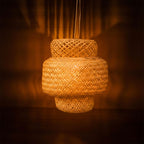 Woven rattan pendant light against a dark background