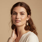 Woman wearing large, round earrings against a beige background