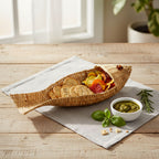 Woven fish-shaped bread basket with crackers and vegetables on a wooden table.