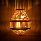 Woven lampshade casting a warm glow against a dark background