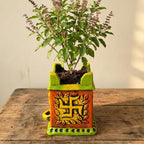 Decorative planter with a plant on a wooden surface