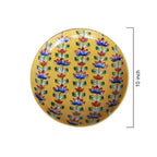 Decorative plate with floral pattern on a yellow background, featuring measurements.