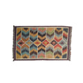 Multicolored geometric patterned rug with fringe on a white background