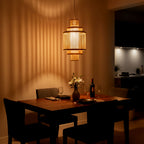 Dining room with a wooden table set for two, featuring a vase of flowers and wine glasses.