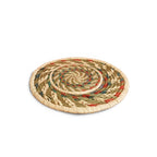 Round woven trivet with multicolor pattern on a white background