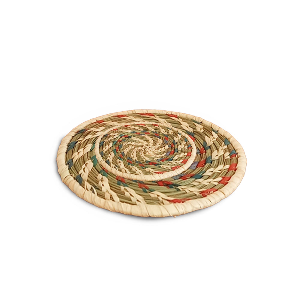 Round woven trivet with multicolor pattern on a white background