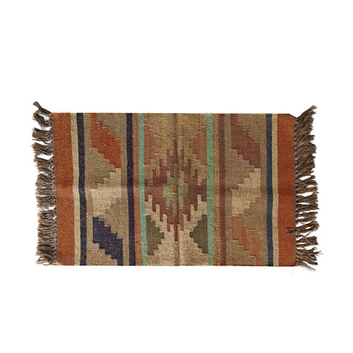 Woven rug with geometric pattern and fringes on a white background