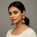 Woman wearing traditional earrings against a neutral background