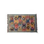 Multicolored patterned rug with fringe on a white background