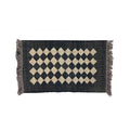 Black and beige diamond patterned rug with fringes on a white background
