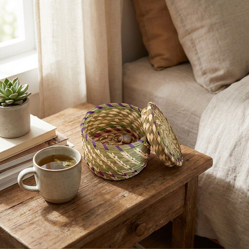 Woven basket and mug on a wooden table near a sofa with pillows and a plant.