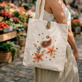 Person holding a tote bag with floral design in an outdoor market setting