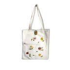 White tote bag with floral patterns on a white background