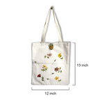 White tote bag with floral designs and measurements on a white background