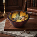 Artisan enamel printed mango wood bowl with golden botanical leaf motif interior set on wooden cutting board