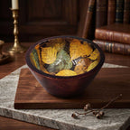 Artisan enamel printed mango wood bowl with golden botanical leaf motif interior set on wooden cutting board
