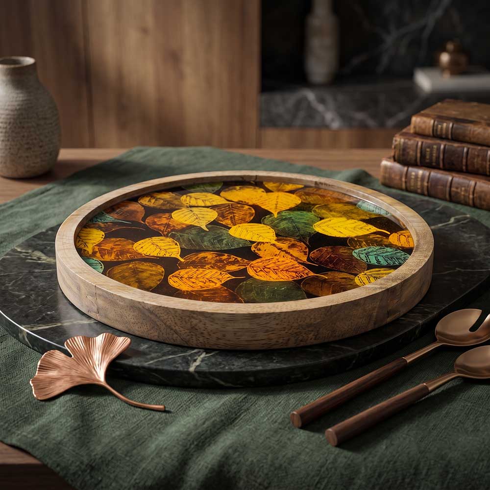 Front view of an artisan round mango wood serving tray with an autumn leaf enamel inlay