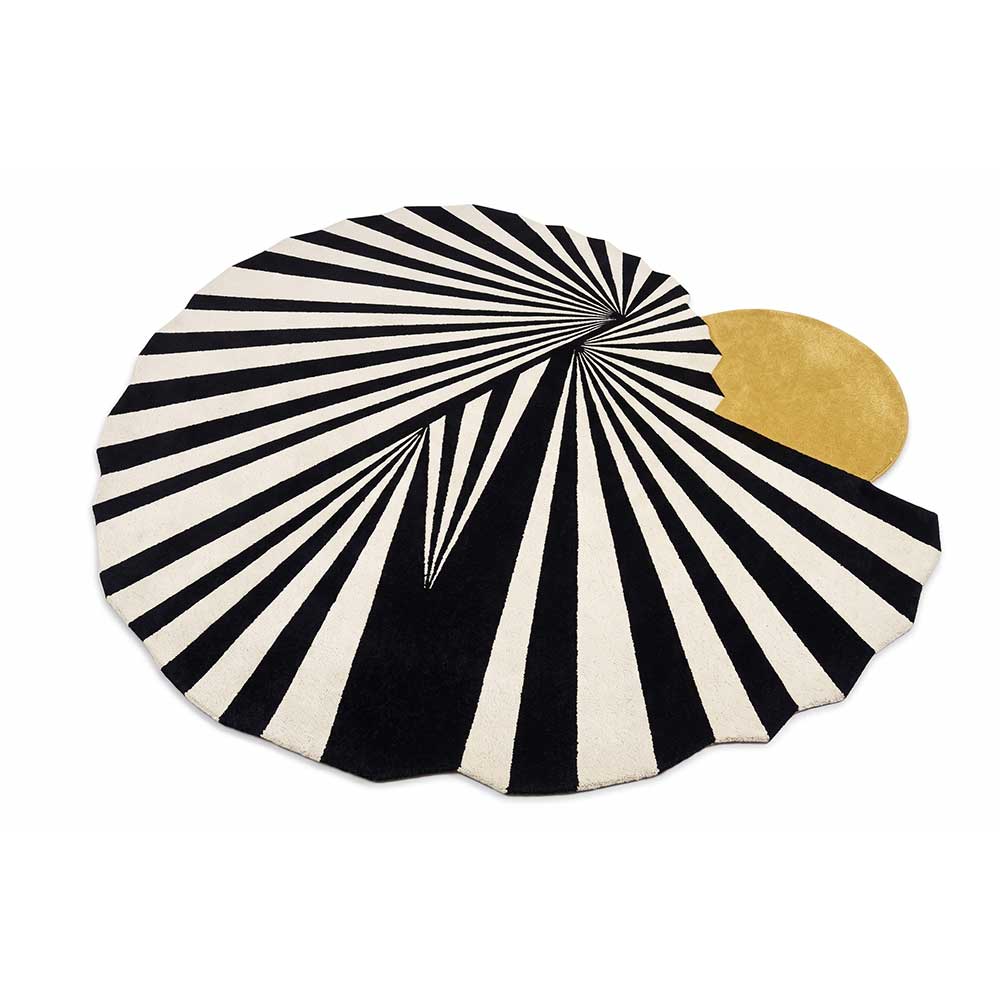 A luxurious round handcrafted New Zealand wool rug with a black and white sunburst pattern and a gold accent piece on an off-white background.