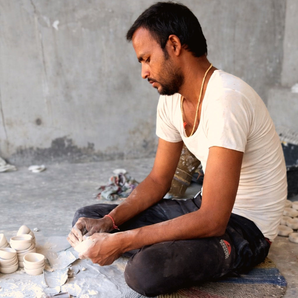 Man working with clay pottery in a workshop setting